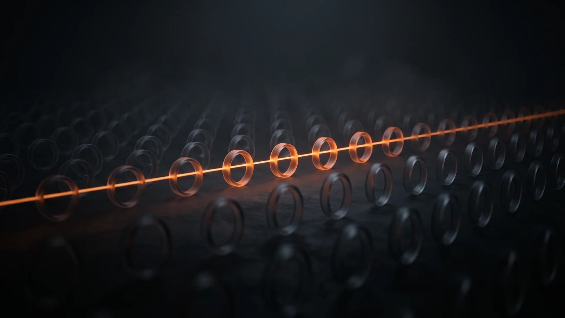 Rows of dark glass rings, with an orange beam of light running straight through the ones that line up